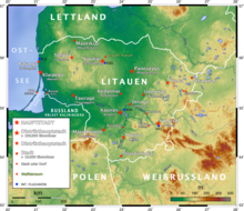 Landkarte Litauens mit farbiger Markierung topografischer Unterschiede. Hauptstadt, Distrikthauptstadt, Stadt, Wallfahrtsort und Flughafen sind eingezeichnet und in der Legende links unten erläutert.