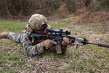 A US Marine with a 2021-standard M27 fitted with a VCOG Squad Common Optic and a KAC suppressor. Marines receive improved optic to identify threats from farther distances 210210-M-KR032-5374.jpg