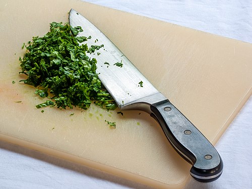 Kitchen knife with cutting board and parsley