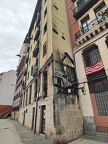 Mural sobre la labor minera de San Luis y puerta de acceso a la galería