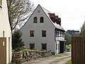 Wohnhaus und Stützmauer eines ehemaligen Bauernhofes