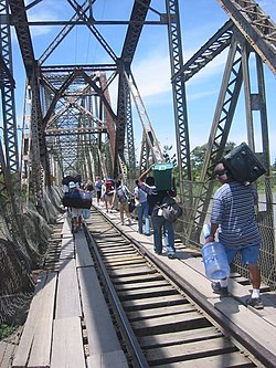 Attraversamento del confine su un ponte ferroviario in disuso che attraversa il Rio Sixaola tra le città di Sixaola (Costa Rica) e Guabito (Panama).