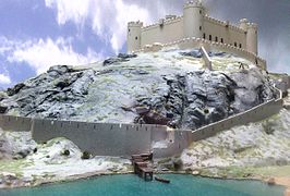 Maqueta de un castillo fortificado construido sobre una cumbre rocosa.