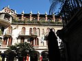 Фотография во дворе гостиницы Mission Inn с четырьмя этажами испанской архитектуры возрождения, арками и черепичными крышами, возвышающимися над головой.