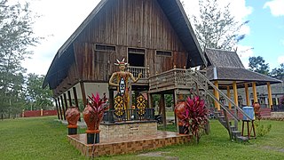 A Huma Betang with Sapundu sculpture at the front of the house in West Kotawaringin, Central Kalimantan