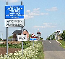 A level crossing in Lincolnshire, showing the improved signage introduced from 1969. This crossing also has an additional warning sign regarding the risk of long vehicles being grounded. Signs at the level crossing - geograph.org.uk - 443093.jpg