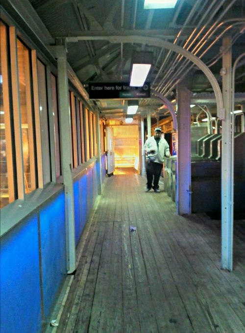 A passenger enters the station as it appears quarter after 7 o'clock in the evening.