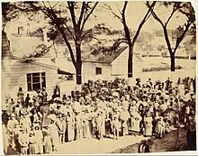 Freed slaves on J. J. Smith's cotton plantation on the Sea Islands near Beaufort, South Carolina, photographed by Timothy O'Sullivan standing before their quarters in 1862 Timothy H. O'Sullivan (American - Slaves, J. J. Smith's Plantation, South Carolina - Google Art Project.jpg