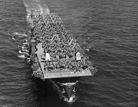 The packed flight deck of Kwajalein during a transport mission, 19 July 1944. Numerous Vought F4U Corsair fighters and Grumman TBF Avenger torpedo bombers are visible.