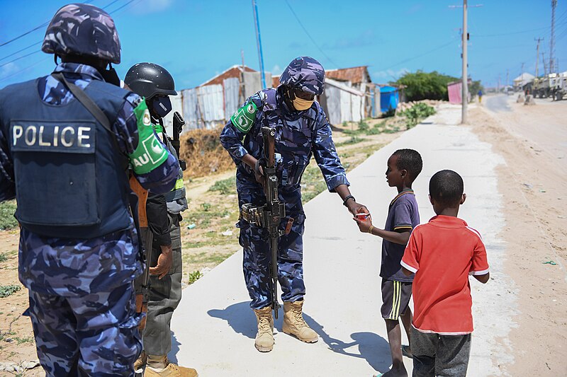 File:Ugandan police officer shares a snack with children in Mogadishu, Somalia (51211384063).jpg