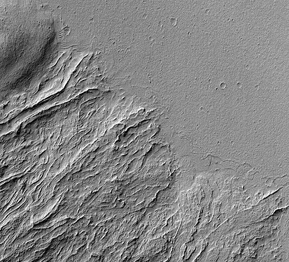 Coulées de lave récentes et anciennes à la base d'Olympus Mons. La plaine correspond à la coulée de lave récente. L'ancienne coulée comporte des canaux bordés de falaises. De telles formations sont fréquentes sur Mars.