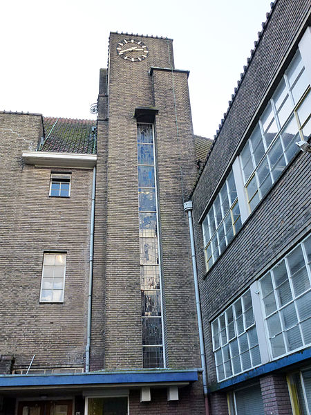 File:Ambachtsschool Gouda. Traptoren, glas-in-lood-ramen en klok.jpg