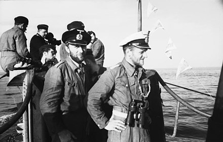 Sur le pont d'un sous-marin allemand : avec sa casquette blanche, le célèbre commandant Erich Topp.