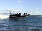 Clearance divers speed out to their dive site on a fast insertion boat