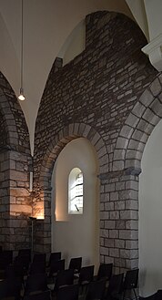 Intérieur du mur gouttereau sud avec une fenêtre d'étage partiellement masquée.