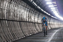 Cycling on the screed surface in the Channel Tunnel service tunnel, between the two railway tunnels Chris Froome - The First Man to Cycle through the Eurotunnel (14570544596).jpg