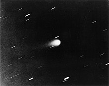 Gray scale photograph of Kohoutek, appearing as a bright, teardrop-shaped object at center with a faint tail