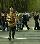 A man dressed as a veteran of the Great Patriotic War wearing both a gymnastyorka and a pilotka.