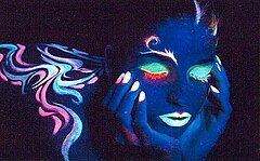 Photographie sous ultraviolet d'un modèle maquillé à l'aide de pigments fluorescents