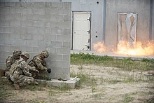 Idaho National Guard combat engineers practice explosive breaching. Explosive breach charges have been placed on the adjacent door's hinges. Fire in the hole! Idaho combat engineers practice explosive breaching Image 30 of 31 7181597 220506-Z-AY311-0200.jpg