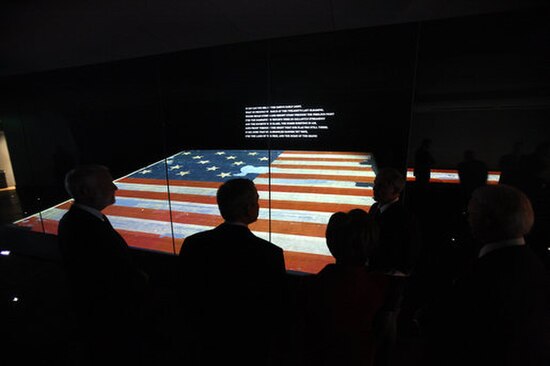 President George W. Bush (center) observes the flag upon its unveiling at the reopening of the National Museum of American History in 2008