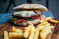 Homemade burger with french fries on wooden board (49106185363).jpg