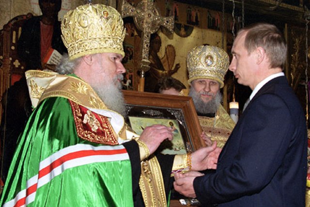 Alexy, in the Kremlin Cathedral of the Annunciation, presents Vladimir Putin with an icon of Saint Alexander Nevsky at the latter's presidential inaug