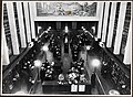 Hovedutlånet ved Deichmanske bibliotek på Hammersborg, trolig på 1930-tallet. I 1932 dekorerte Axel Revold fondveggen i hovedhallen med fresken «Teknikk, vitenskap, diktning».[1] Foto: Nasjonalbibliotekets bildesamling