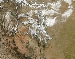 Snow highlights the rugged mountains as well as the urban and agricultural landscapes of the Colorado plains.