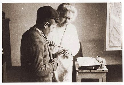 A woman doctor tends to a young man who has injured his hand