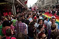 English: LGBT workers from Tesco and EDF carry a giant rainbow flag down Regent Street while crowds jostle.