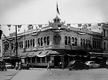 Rockhampton decorated with flags and bunting, as it prepares for the arrival of the Queen and the Duke of Edinburgh, 1954 Rockhampton prepares for the arrival of The Queen and Duke of Edinburgh (6944869599).jpg
