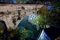 Roman Arch ruins over the Tiber River or Tevere at night Rome, Italy