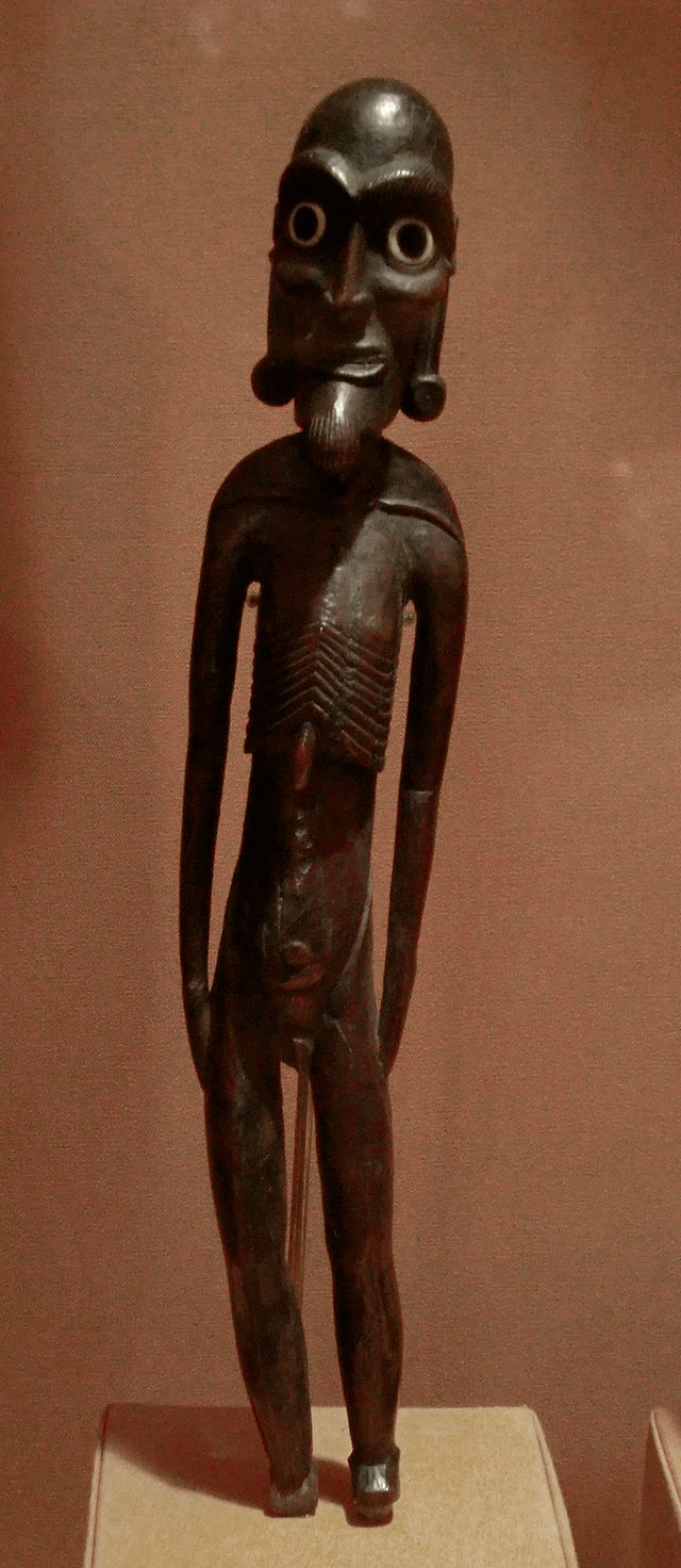 a colour photo of a thin male statuette in dark brown wood