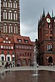 Fontäne auf dem Alten Markt in Stralsund. Im Hintergrund die Nikolaikirche und das Rathaus.