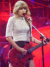 Taylor Swift synger "Rød" over en elektrisk guitar