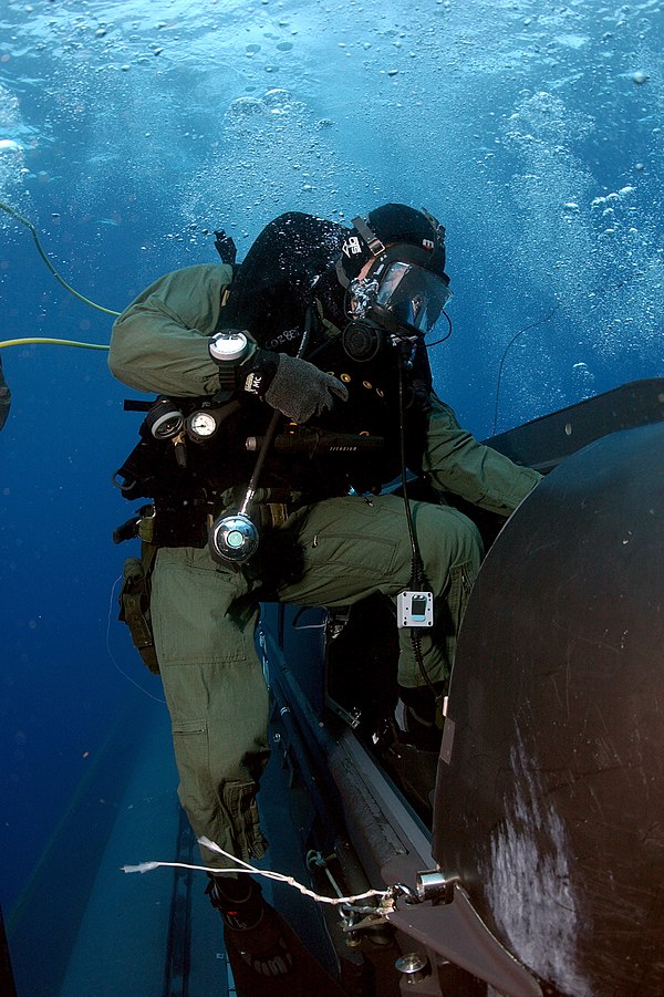 A SEAL Delivery Team member climbs aboard a delivery vehicle before launching from the back of the submarine USS Philadelphia.