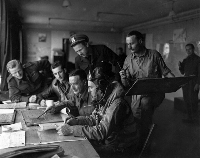 US Navy pilots are briefed before flying a gunfire spotting mission over the Normandy beach heads