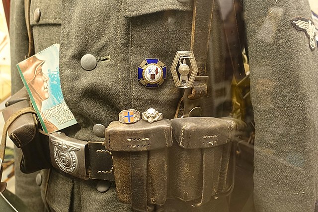 Soldiers' songbook in Norwegian ("Frontkjemper sangbok"), badges and rings; Lofoten War Museum, Norway.