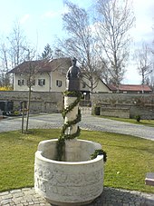 Simon Spannbrucker in Bronze als Prediger auf einem Brunnen in Fridolfing