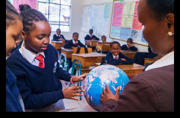 File:Teacher points to a globe.jpg