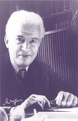 Manuel Ponce sitting at desk looking into camera holding a pen