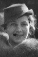 A young white woman, smiling, wearing a hat with a low brim.