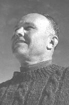 A black and white photo of a middle-aged man wearing a sweater