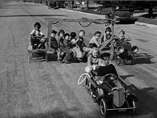 The gang races rich-kid Jerry Tucker in their makeshift fire engine in the 1934 short Hi'-Neighbor!