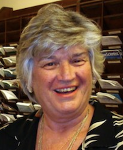 a tight headshot of an older white woman with short grey hair, she is smiling