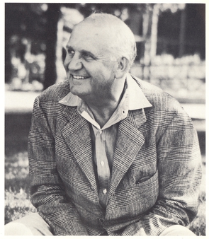 William M. "Skipper" Beals sentado no gramado em frente ao Edifício Homestead original no campus Leelanau for Boys ca.  1940