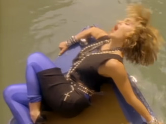 Madonna in the "Like a Virgin" video, riding on a gondola, wearing a number of garlands around her neck.