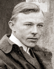 A grainy surveillance photograph of Max Gerlach clandestinely taken by New York City police operatives. Gerlach appears blonde-haired and immaculately groomed. He is wearing a high starch collar and a large brown overcoat.