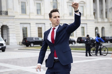 Hawley gives a raised fist salute to pro-Trump protesters outside of the U.S. Capitol on January 6, 2021. Some of these protesters stormed the Capitol building about an hour later.[124]
